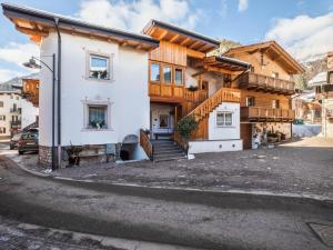 ein Haus mit einer Treppe vor einer Straße in der Unterkunft Chalet Osmar Appartamento 1 in Campitello di Fassa