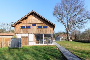 a large wooden house with a large window at Cuicui les p'tits oiseaux in Lesperon