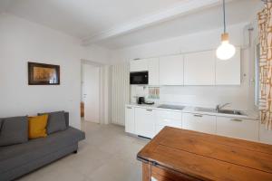 a living room with a couch and a kitchen at Casa Mavi in Corte Franca