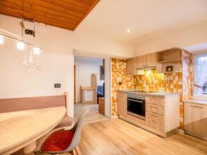 eine Küche mit einem Holztisch und einem Esszimmer in der Unterkunft Chalet Osmar Appartamento 1 in Campitello di Fassa