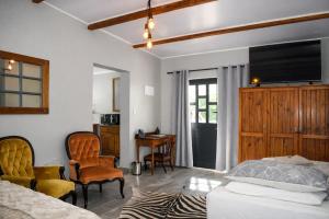a bedroom with a bed and a desk and chairs at Little Lamb in Beaufort West