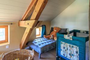 a stuffed teddy bear sitting on a bed in a room at Cuicui les p'tits oiseaux in Lesperon