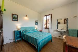 a bedroom with a blue bed and a sink at Chalet des Bruyères in Saint-Jorioz