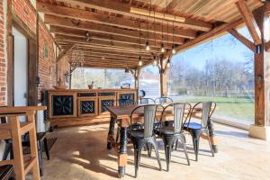 a dining room with a wooden table and chairs at Cuicui les p'tits oiseaux in Lesperon