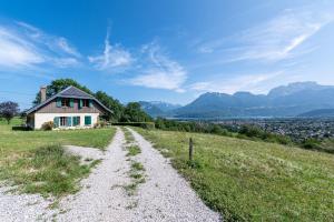 a house on top of a hill with a dirt road at Chalet des Bruyères in Saint-Jorioz