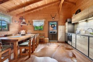 a kitchen with a wooden ceiling and a large wooden table at Pröllerhütte in Grün