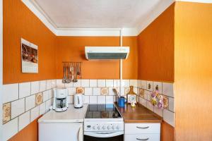 a kitchen with orange walls and a stove top oven at Fachwerkferienhaus in Ulrichshusen