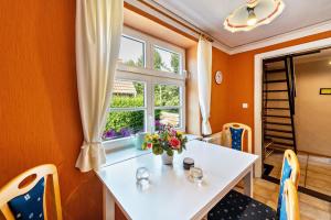 a dining room with a white table and a window at Fachwerkferienhaus in Ulrichshusen +25 photos