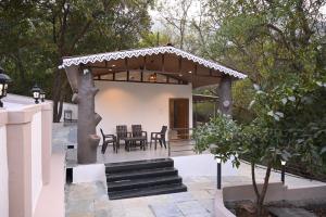 a pavilion with a table and chairs in a garden at Crystal Water in Mulshi