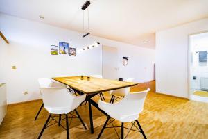 a dining room with a wooden table and white chairs at Kim Fewo 2 in Emmendingen +5 photos