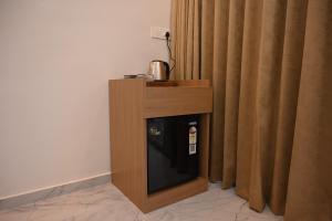 a cabinet with a small refrigerator in front of a curtain at Crystal Water in Mulshi