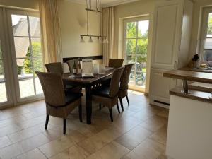 a dining room with a black table and chairs at Villa Sorgenfrei in Zinnowitz