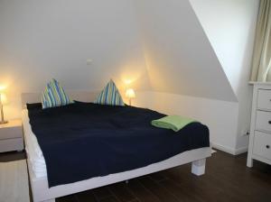 a bedroom with a black bed with blue sheets at Villa Sorgenfrei in Zinnowitz
