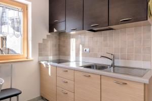 a kitchen with wooden cabinets and a sink at Innerjerberhof Sunnseit in Lauregno