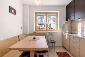 a small kitchen with a wooden table and a window at Innerjerberhof Sunnseit in Lauregno