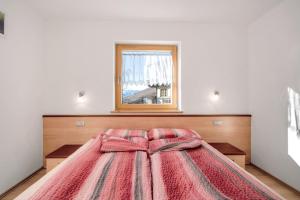 a large bed in a room with a window at Innerjerberhof Sunnseit in Lauregno