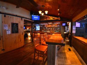 a bar with wooden chairs and a wooden table at Hyde Away Inn in Waitsfield