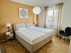 a bedroom with a large bed and a chandelier at Residence La Villa Kalliste in Olzano