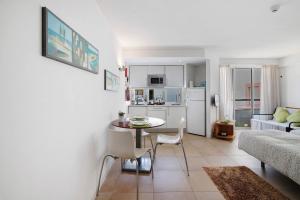 a kitchen and living room with a table and a couch at Casa Diouma in Cabanas de Tavira