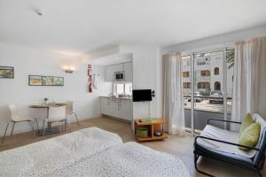a living room with a bed and a dining room at Casa Diouma in Cabanas de Tavira
