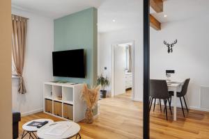 a living room with a television and a table at Kaiserstuhlnest am Rhein in Breisach am Rhein