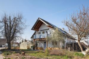 a white house with a balcony on top of it at Kaiserstuhlnest am Rhein in Breisach am Rhein