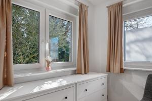 a bedroom with two windows and a white dresser at Kaiserstuhlnest am Rhein in Breisach am Rhein +24 photos