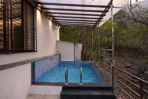 a swimming pool on the side of a building at Crystal Water in Mulshi