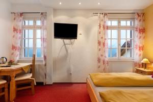a room with two beds and a television on the wall at Landhaus Christophorus in Forbach