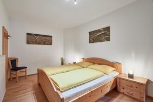 a bedroom with a bed and a desk and two paintings at Mareiter Stein Blasighof in Racines