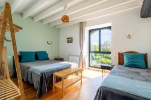 a bedroom with two beds and a window at L'Erdre au moulin in Joué-sur-Erdre