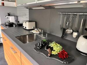a kitchen counter with a bunch of grapes on a cutting board at Ferienwohnung Krenz in Uhldingen-Mühlhofen