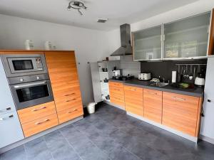 a kitchen with wooden cabinets and stainless steel appliances at Ferienwohnung Krenz in Uhldingen-Mühlhofen