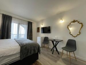 a bedroom with a bed and a table and a mirror at Pensiunea Oficial in Prejmer