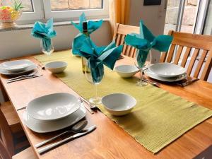 a wooden table with plates and glasses on a table at Ferienwohnung Krenz in Uhldingen-Mühlhofen