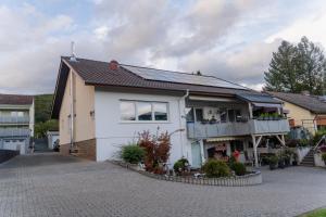 a white house with a balcony on a street at Collenberger Ferienwohnung Schäfer in Collenberg