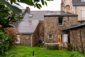 an old stone house with a picnic table in the yard at Maison Sarzeau Centre - La Bernache in Sarzeau
