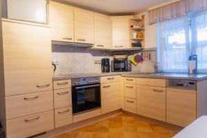 a kitchen with wooden cabinets and a stove top oven at Collenberger Ferienwohnung Schäfer in Collenberg