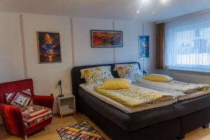 a bedroom with a bed and a chair and a window at Collenberger Ferienwohnung Schäfer in Collenberg