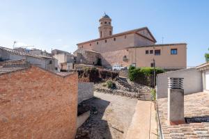 a village with a building and a clock tower at L'Escambell Grau Del Llop in Ulldemolins
