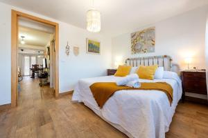 a bedroom with a large bed with yellow pillows at L'Escambell Grau Del Llop in Ulldemolins