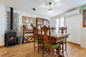 a dining room with a table and a wood stove at L'Escambell Grau Del Llop in Ulldemolins