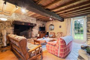 a living room with a stone fireplace and furniture at Ker Cado - Chambre d'hôtes in Mauron