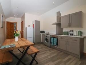 a kitchen with a wooden table and a refrigerator at Meadow View in Hull