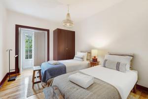 a bedroom with two beds and a chair in it at Quinta do Coração de Jesus in Sintra