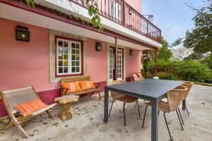 a table and chairs outside of a pink house at Quinta do Coração de Jesus in Sintra