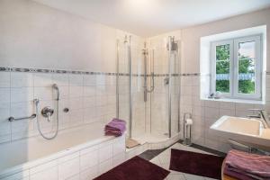a bathroom with a shower and a tub and a sink at Haus Moritz in Heimenkirch +22 photos