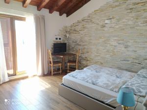 a bedroom with a bed and a table with a television at Agriotto Agriturismo in Savona