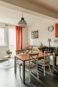 a living room with a wooden table and chairs at L'éclos des vignes - Appartements haut de gamme avec Spa in Bergheim