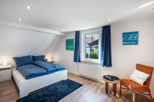 a bedroom with a bed and a chair and a window at Ferienhaus Ludava in Hofmarksgasse